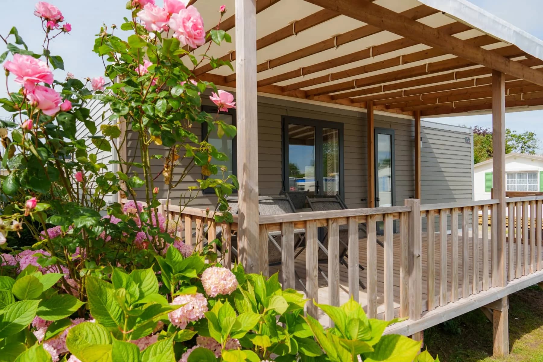 Mobil-home fleuri avec terrasse couverte